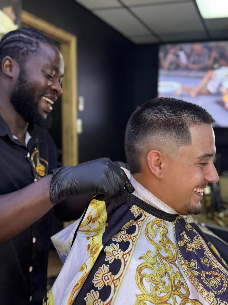 Rama et un client qui rient pendant la finition de la coupe