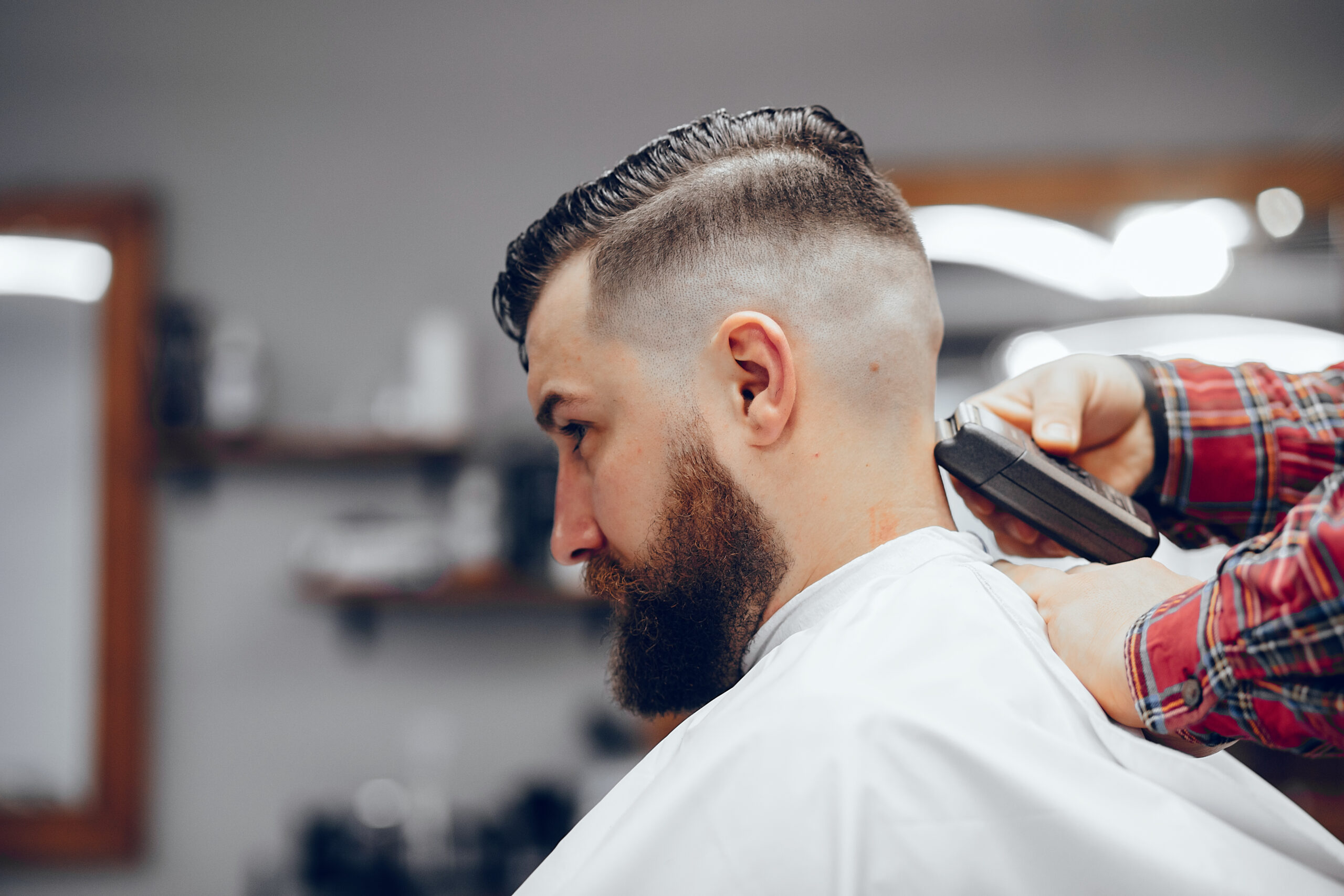 Hairdresser with a client. Man with a beard. Guy in a barbershop